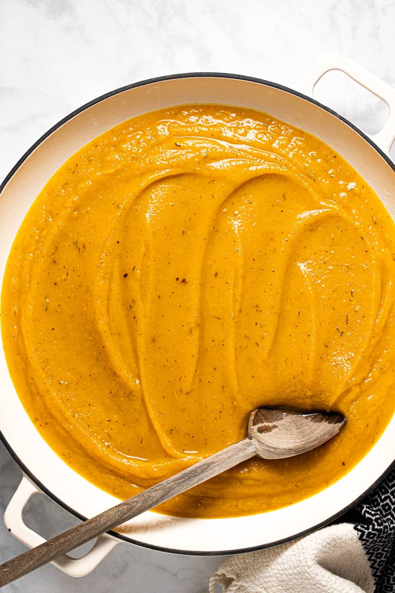 A large white pot filled with creamy roasted squash sauce