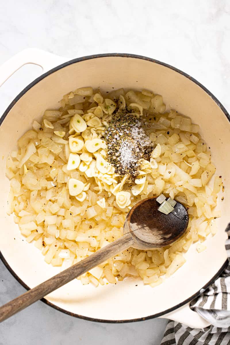 Large white pot filled with ingredients to make tomato gnocchi soup