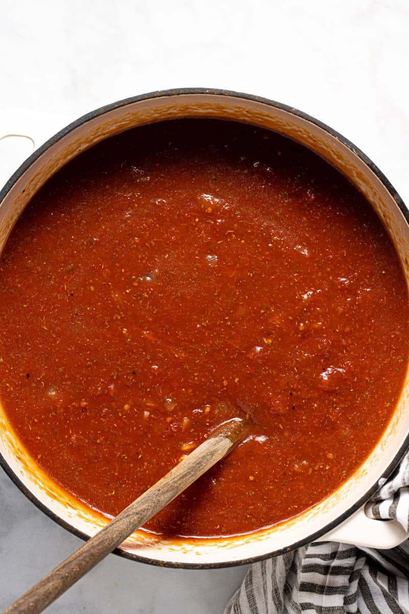 Large white pot filled with ingredients to make tomato gnocchi soup