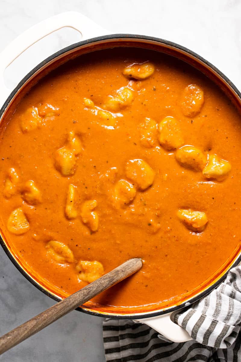 Large white pot filled with homemade tomato gnocchi soup