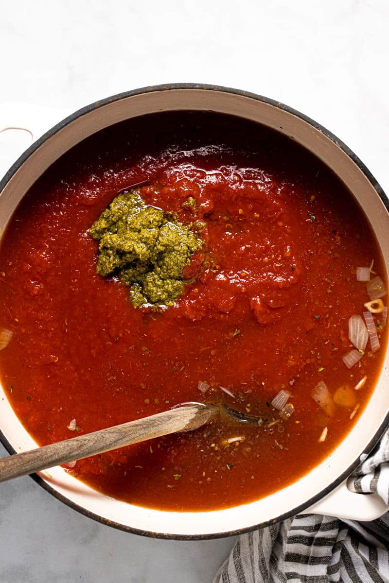 Large white pot filled with ingredients to make tomato gnocchi soup