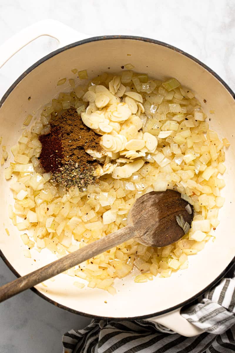 Large white pot with onion garlic and spices