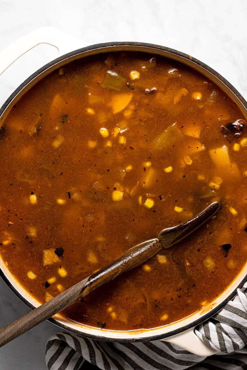 Large white pot with ingredients to make vegan corn chowder