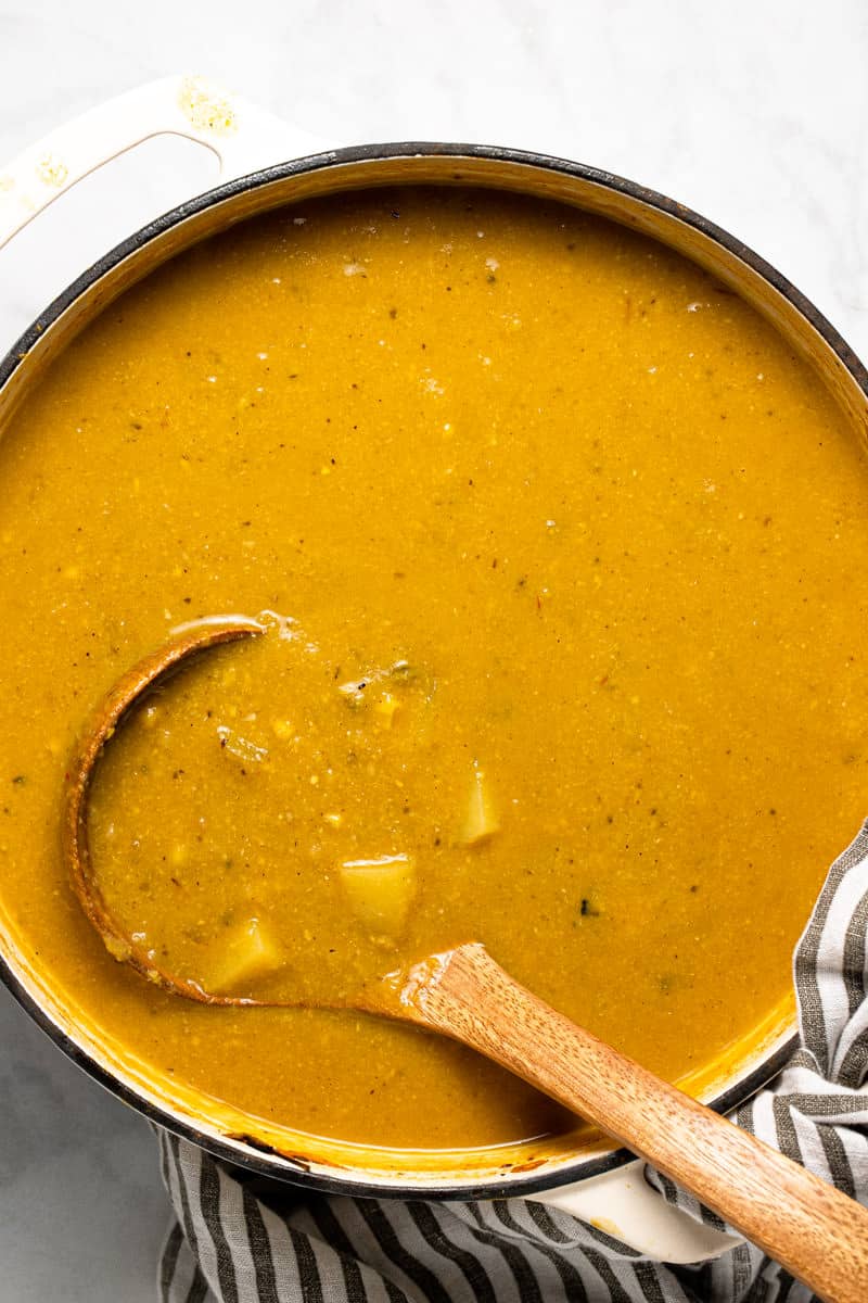 Large white pot with ingredients to make vegan corn chowder