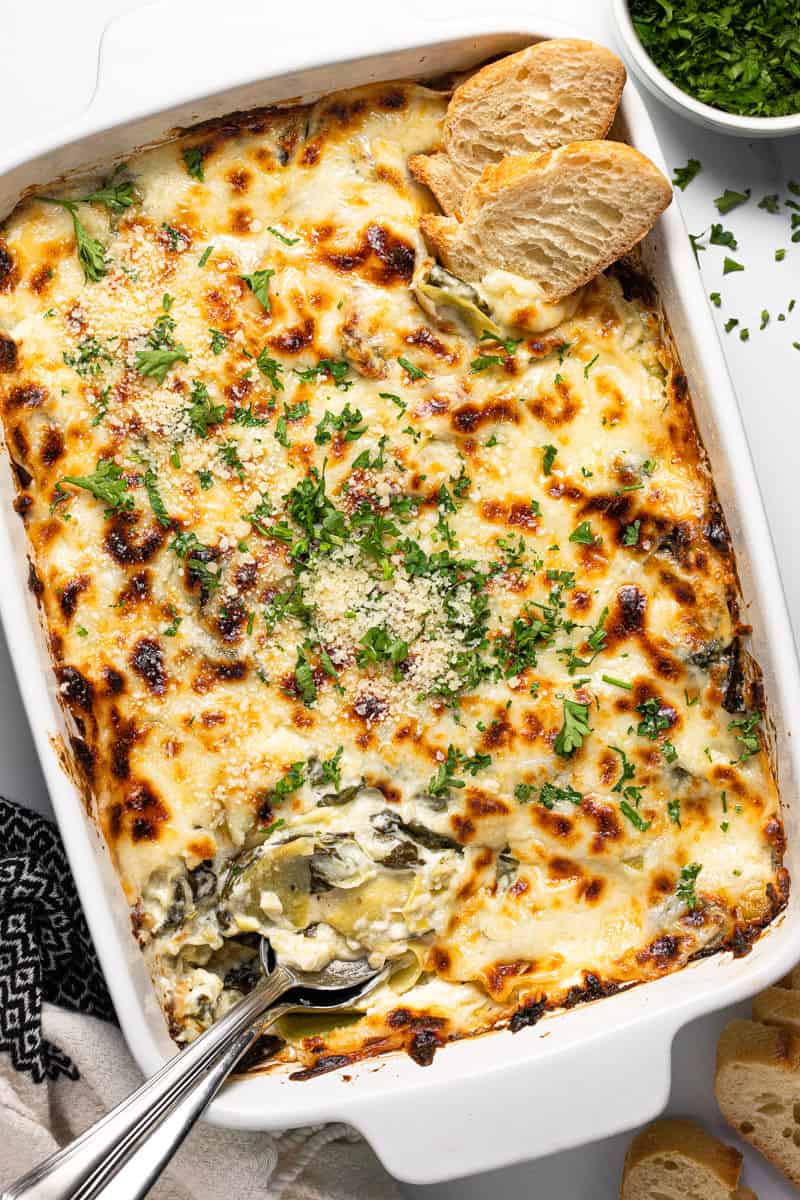 Large rectangle baking dish filled with homemade spinach and artichoke dip.