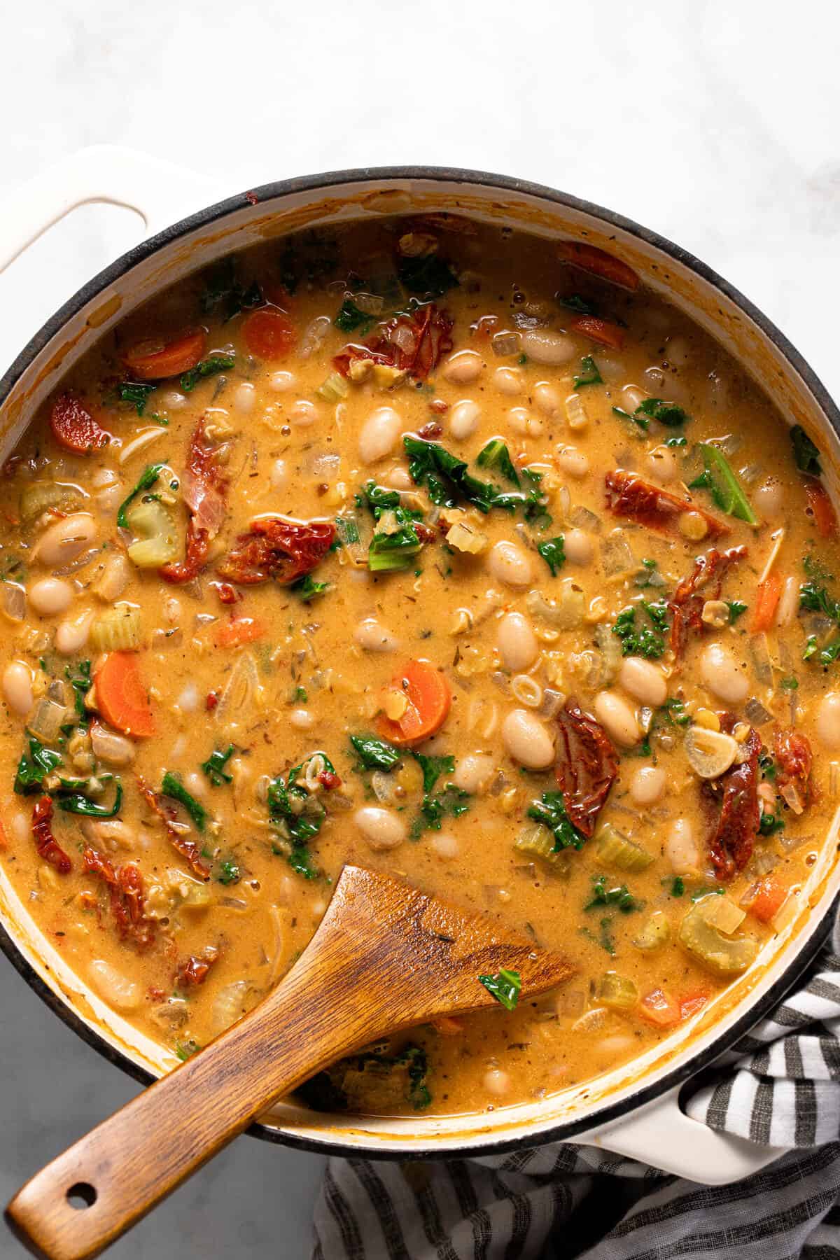 Large white pot filled with creamy vegan white bean stew