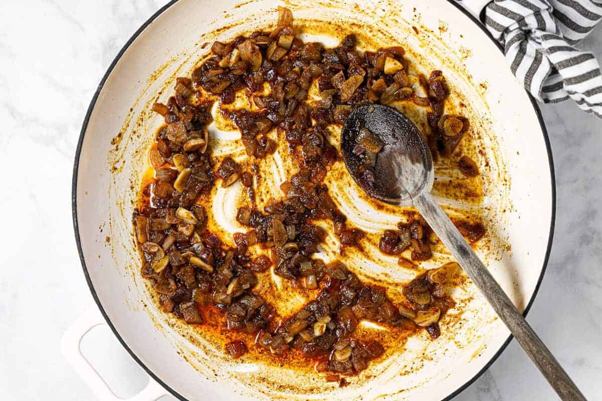White pan with sauteed onion garlic and spices in it