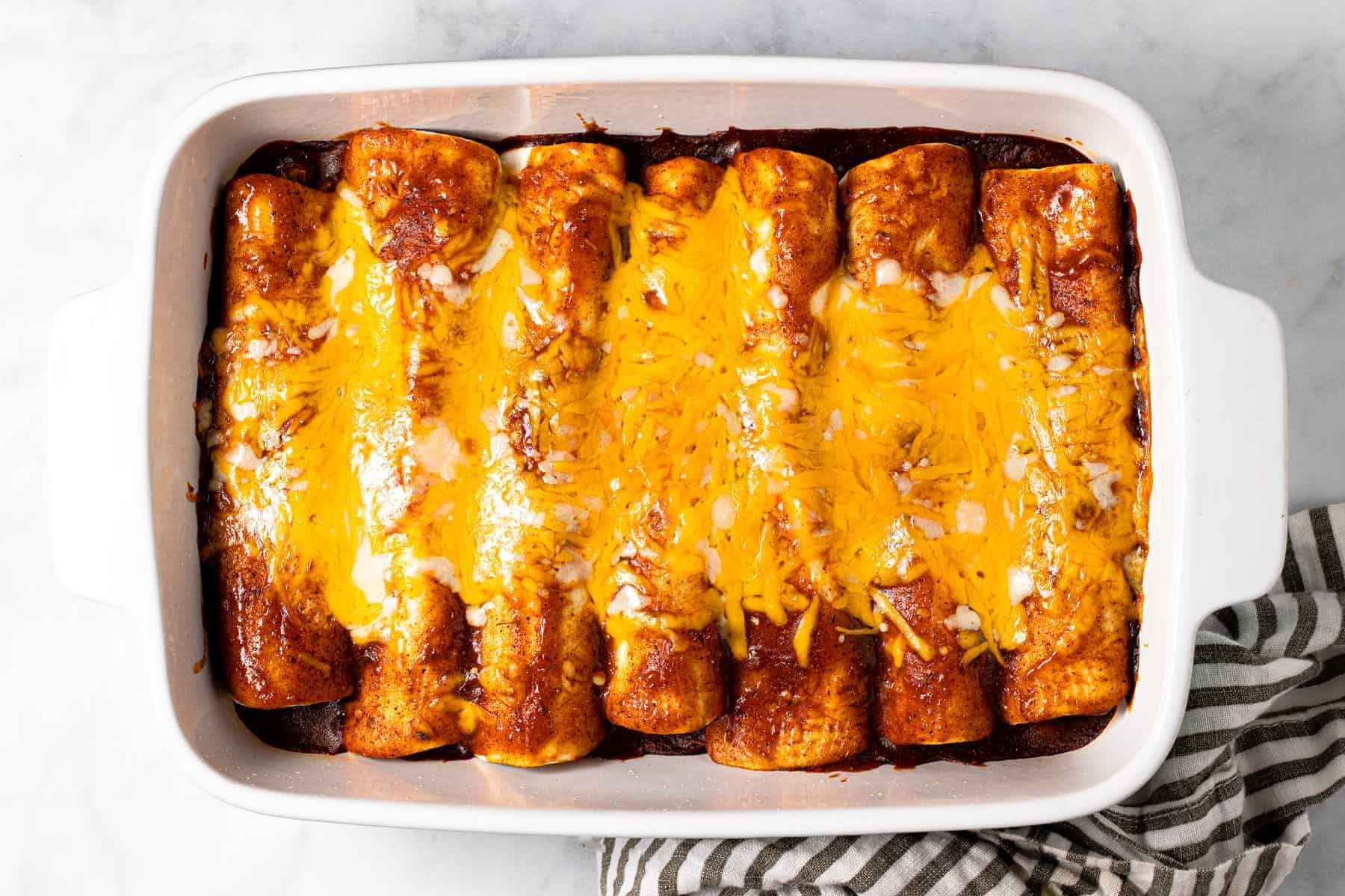 White baking dish filled with homemade black bean and corn enchiladas