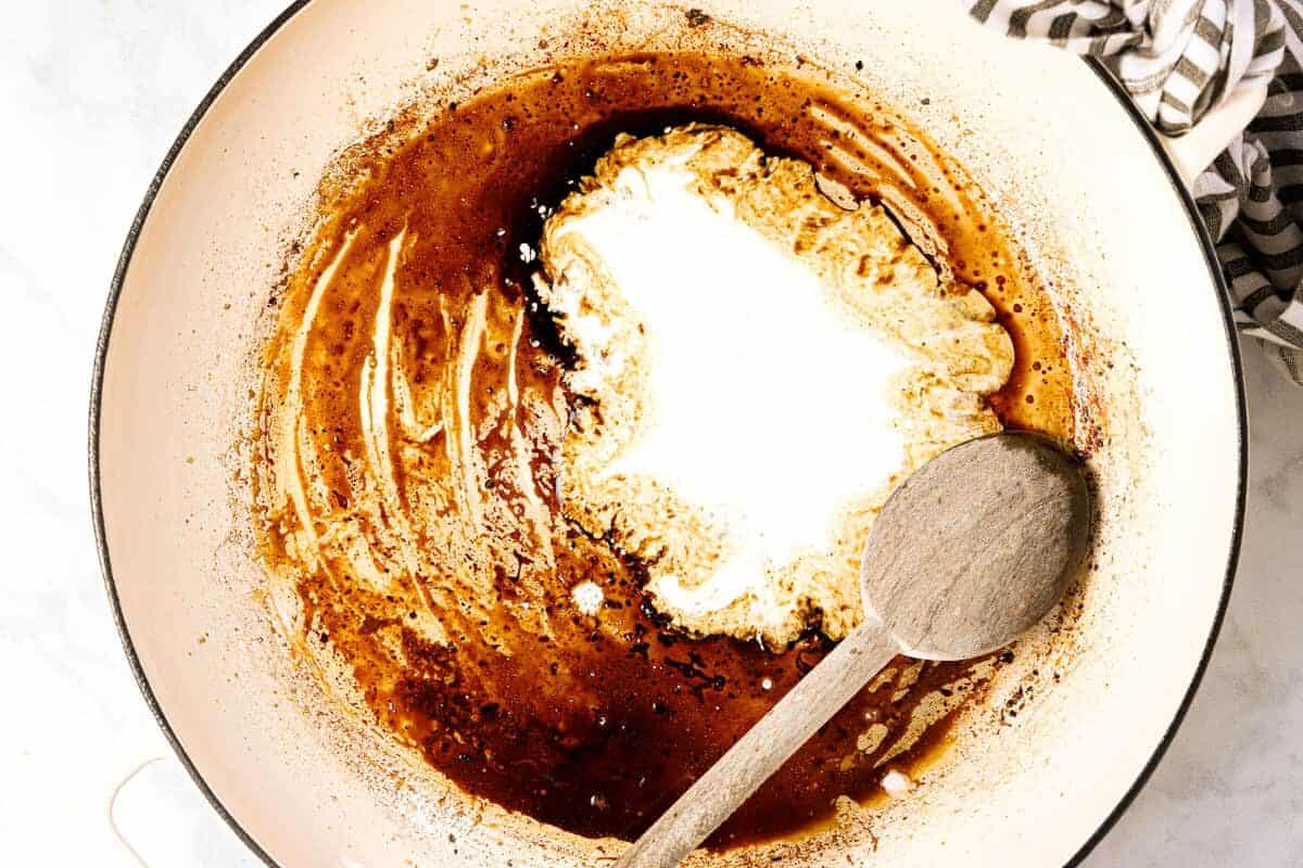 Large white pan with balsamic vinegar and heavy cream in it
