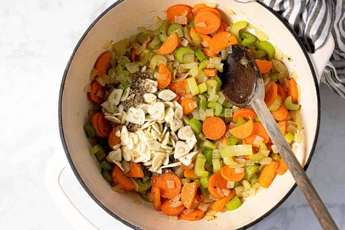 Large white pot filled with ingredients to make creamy vegan gnocchi soup