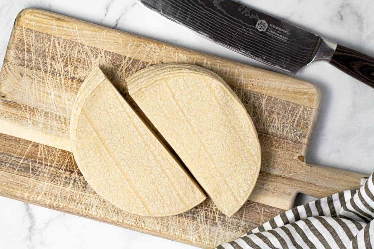 Small cutting board with corn tortillas cut in half