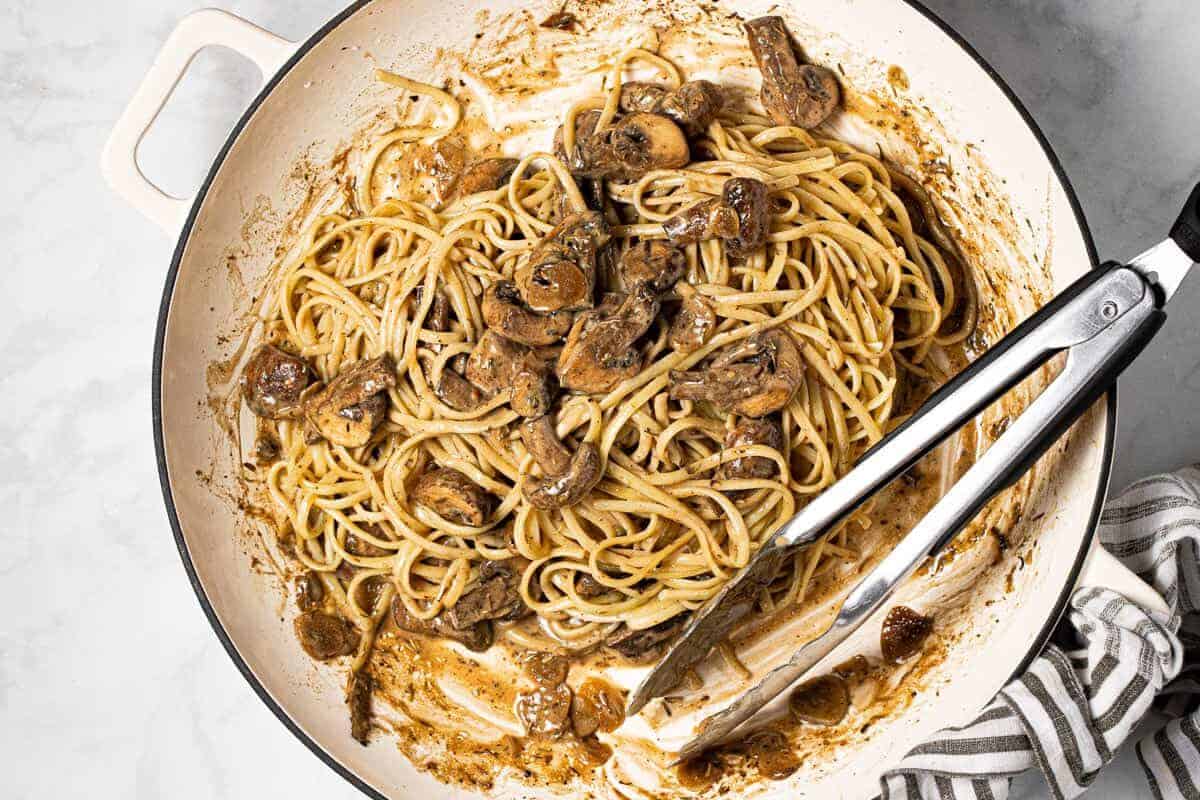 Large white pan filled with homemade creamy mushroom linguine 