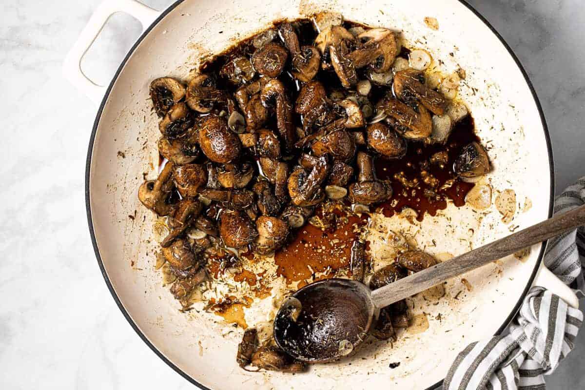 Large white pan with ingredients to make a creamy mushroom sauce