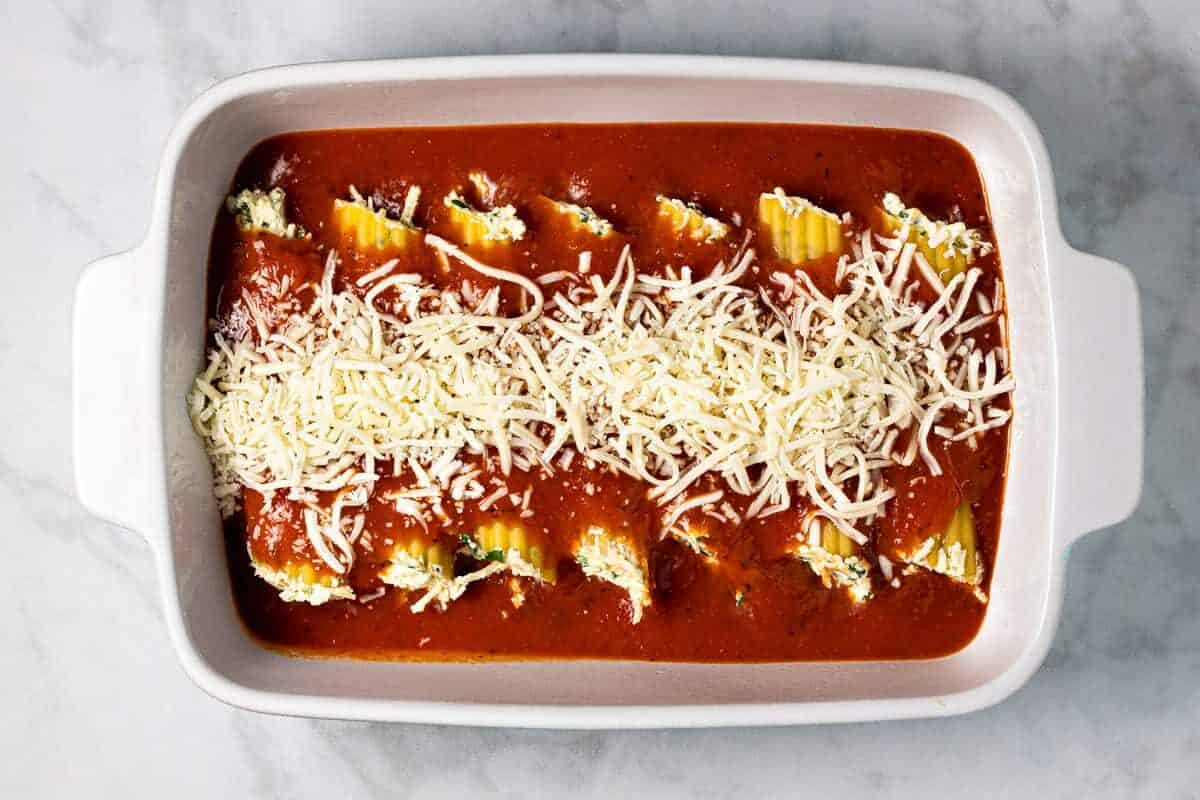 White baking dish filled with homemade baked manicotti before it goes in the oven