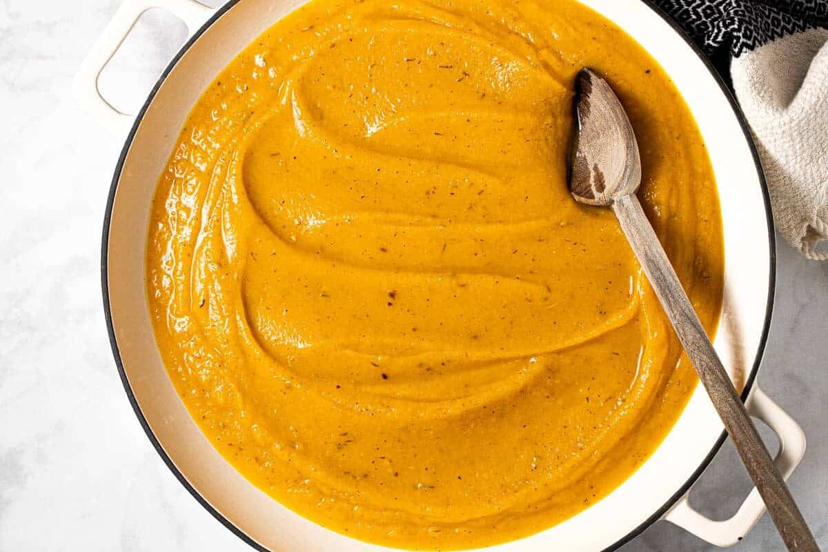 A large white pot filled with creamy roasted squash sauce