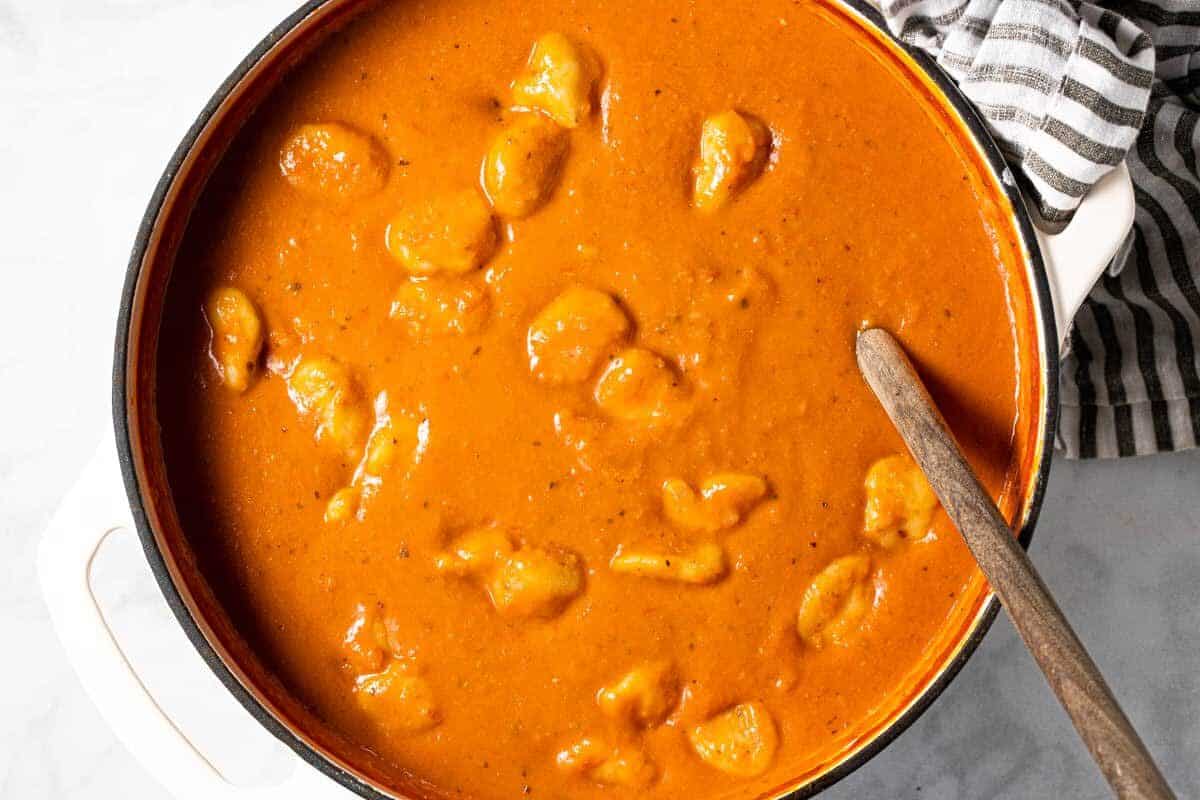 Large white pot filled with homemade tomato gnocchi soup 