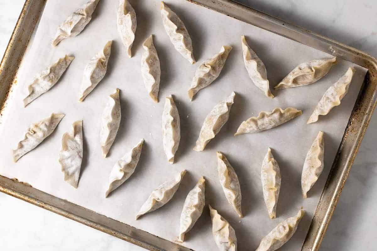 Parchment lined baking sheet filled with homemade vegan dumplings