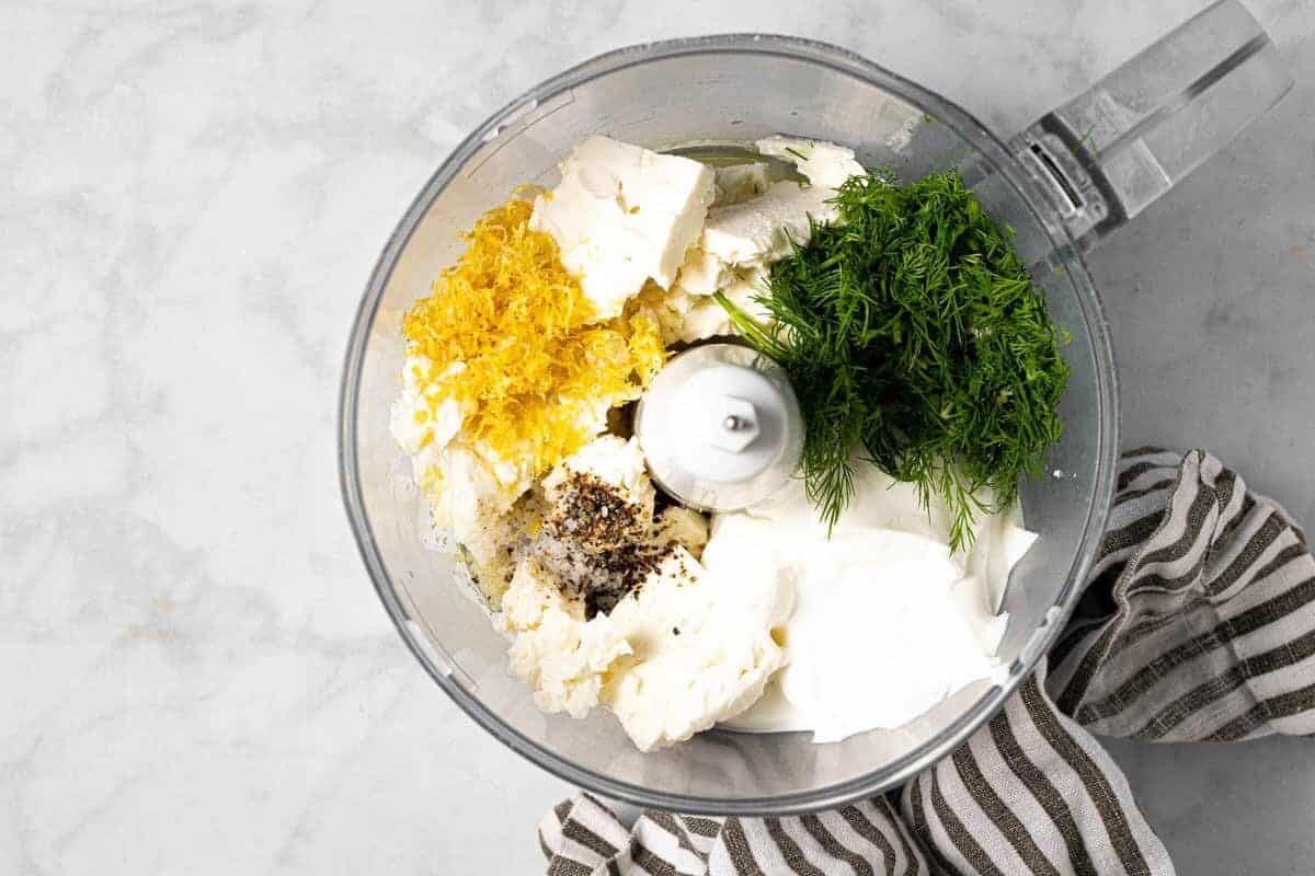 Food processor filled with ingredients to make whipped feta dip