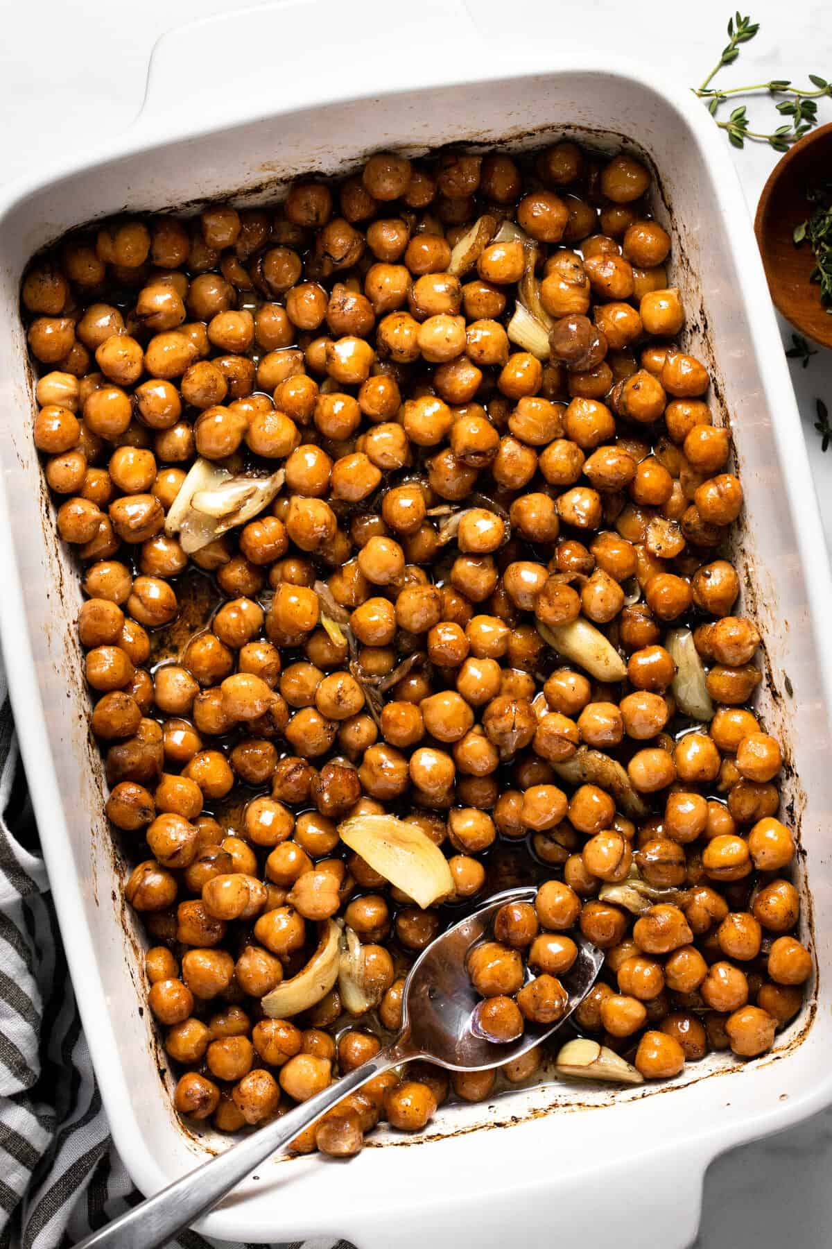 Ingredients to make braised chickpeas in a large white baking dish