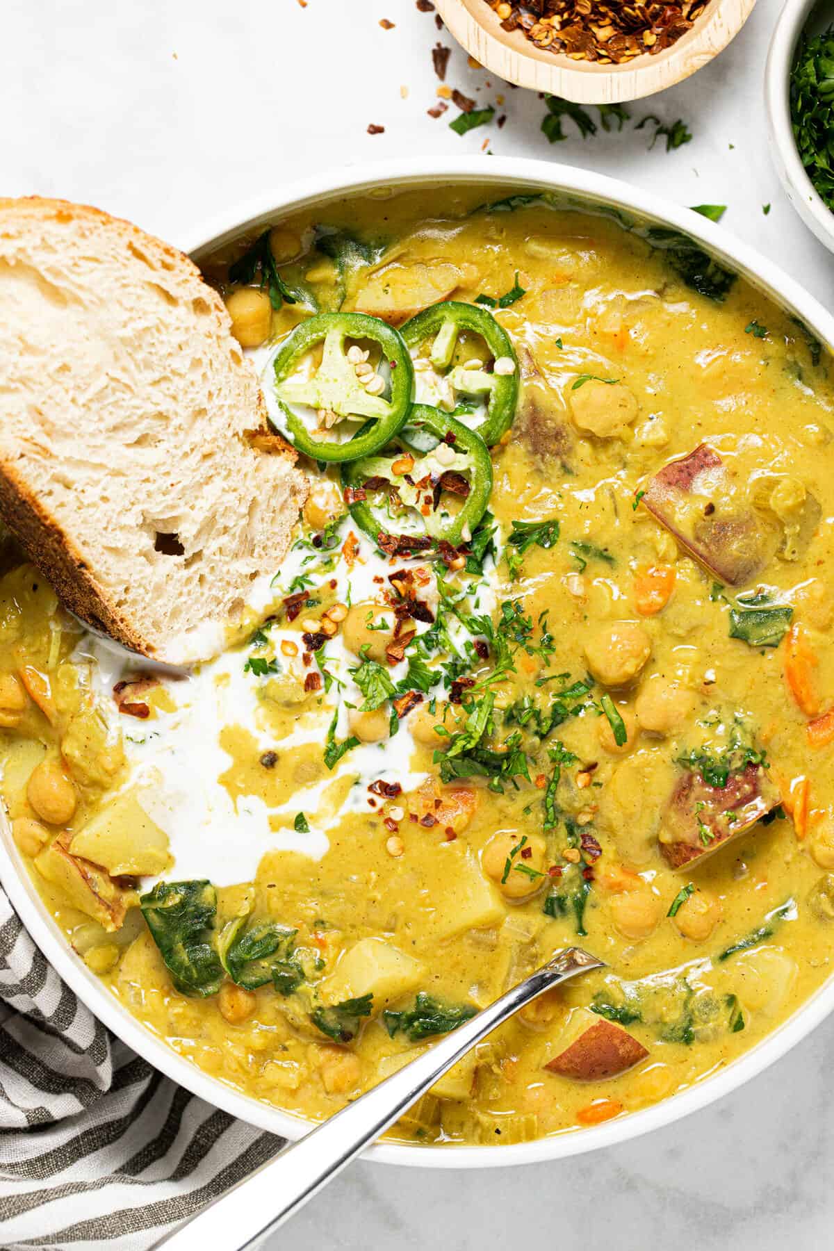 Large white bowl filled with creamy curry chickpea stew