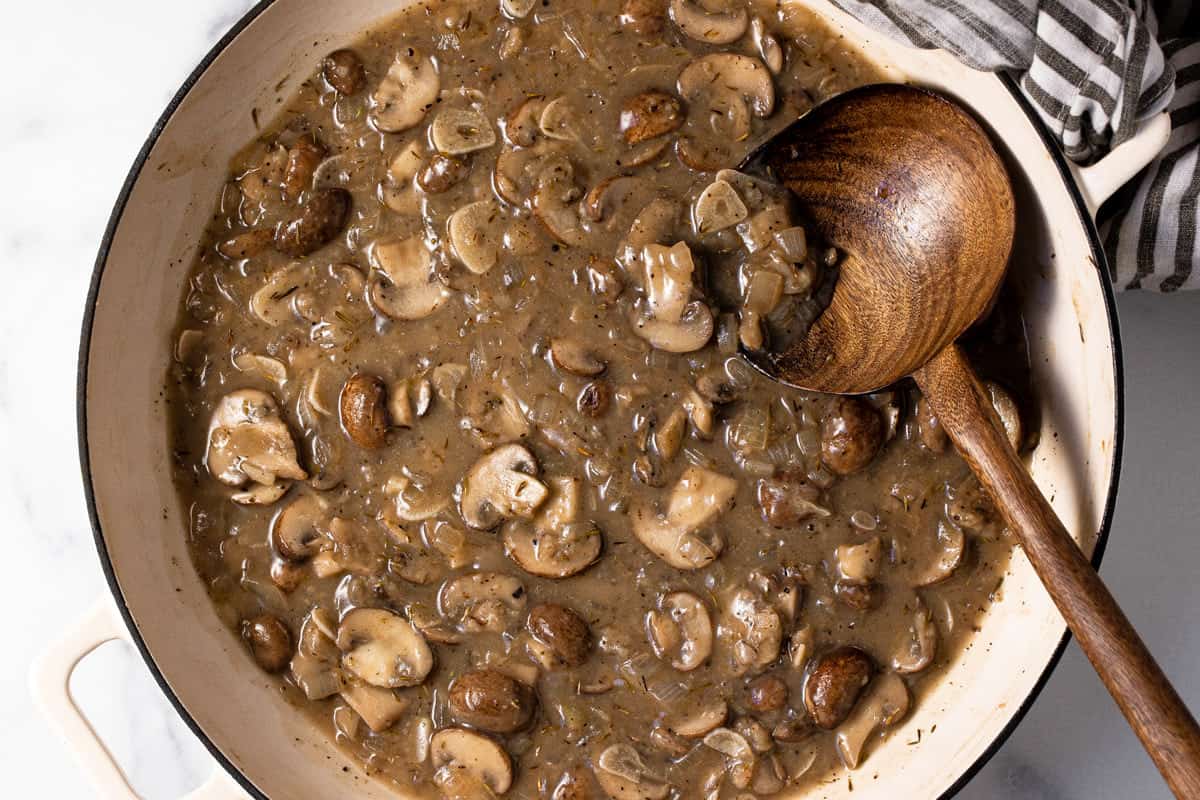 Large white pan filled with sautéed mushrooms in a creamy sauce