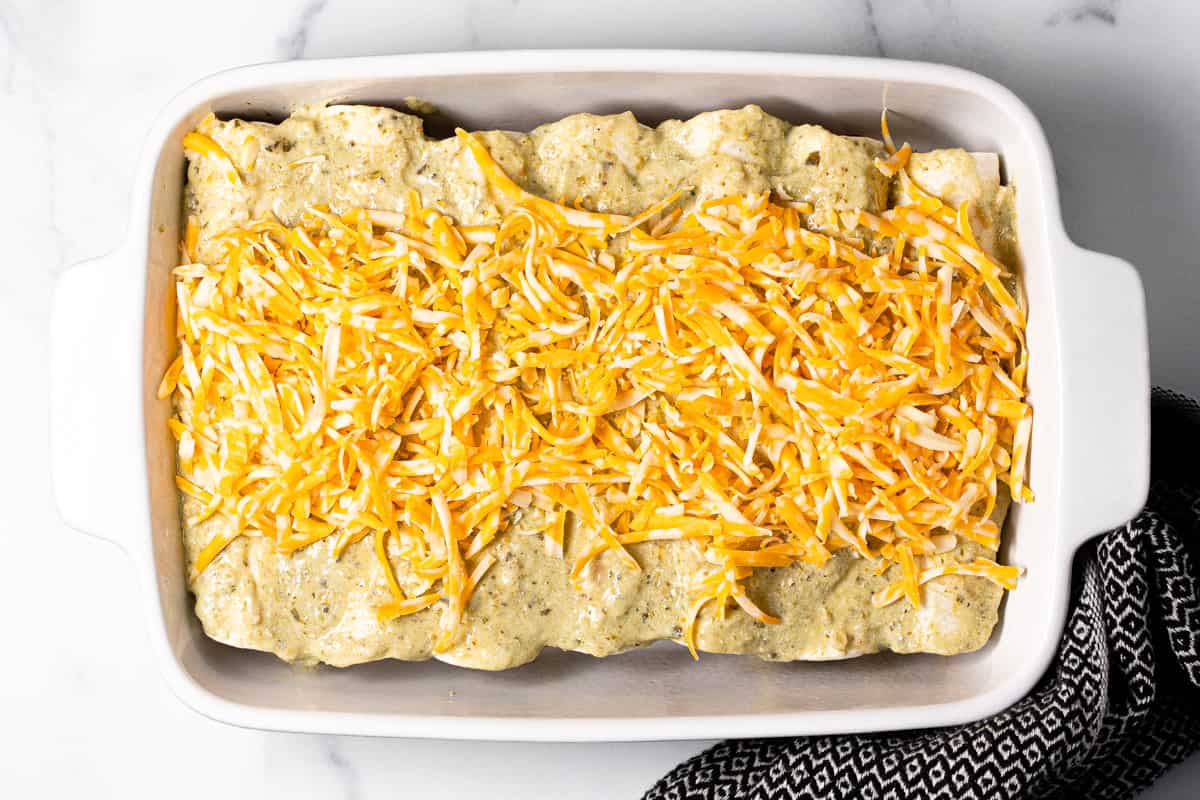 White baking dish filled with pork enchiladas before they go in the oven