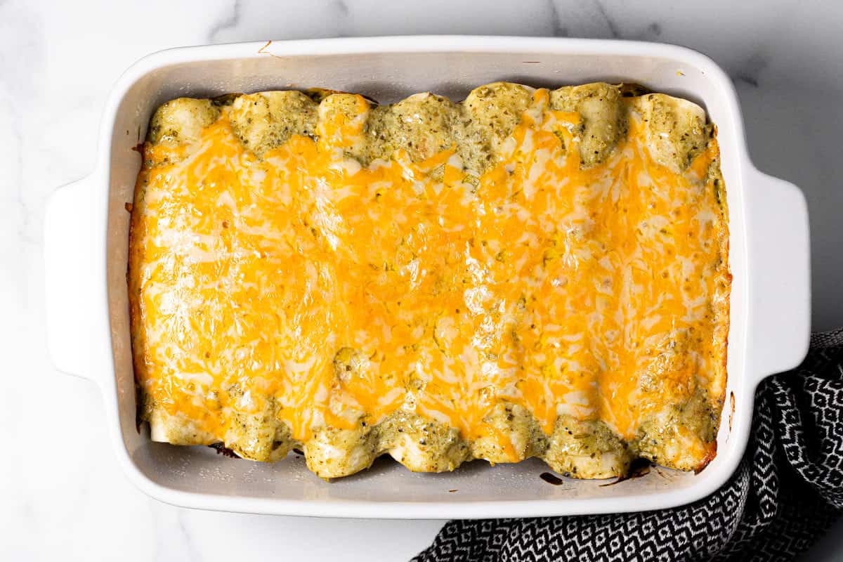 Large white baking dish filled with pork enchiladas fresh baked in the oven