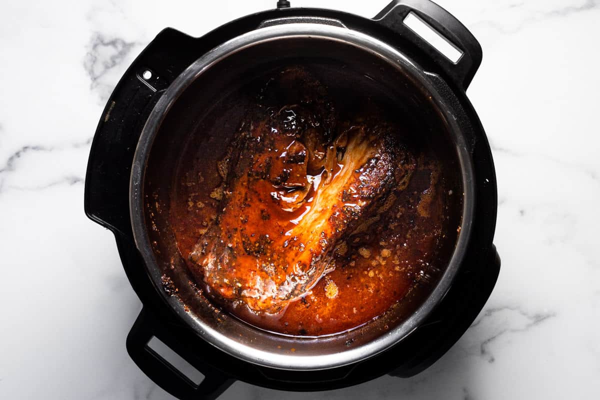 Instant pot filled with ingredients to make BBQ pulled pork