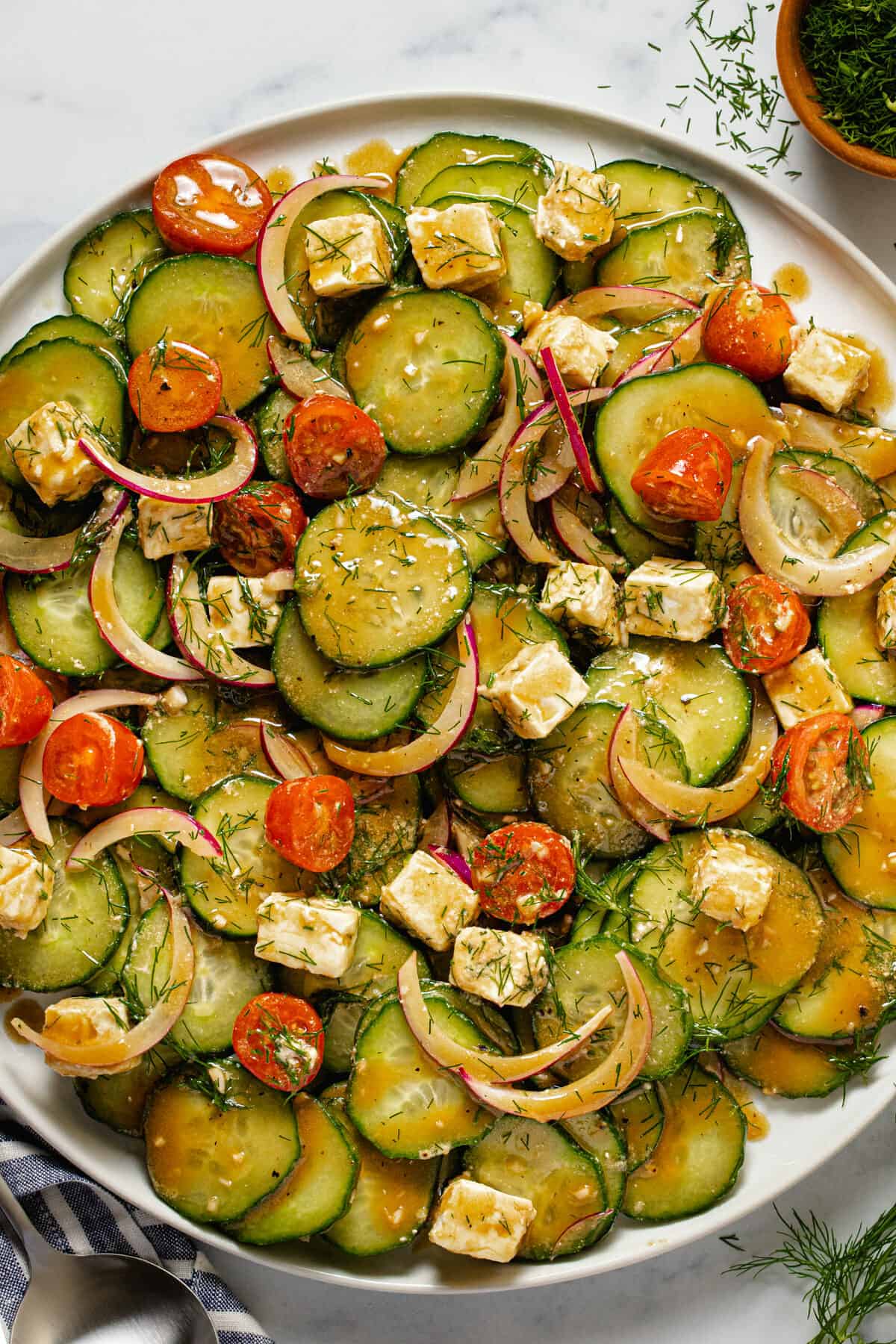 Large white serving platter filled with Mediterranean onion cucumber salad