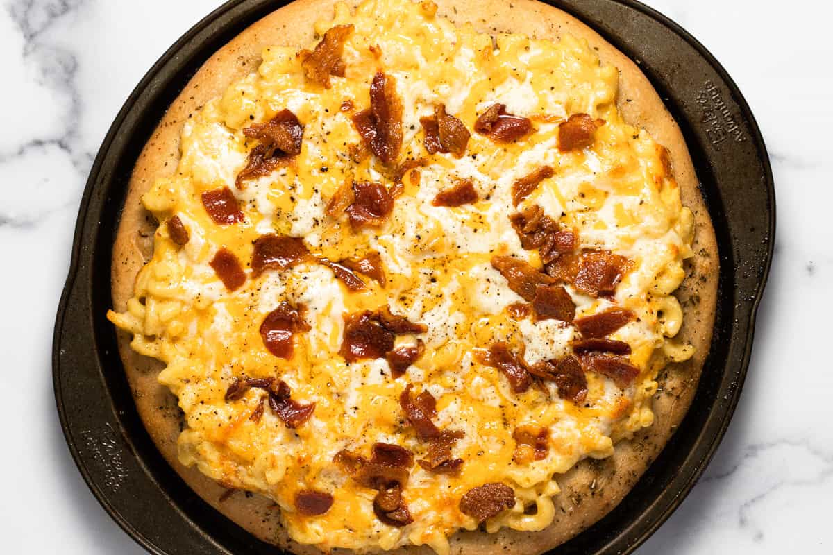 Freshly baked mac and cheese pizza with crumbled bacon