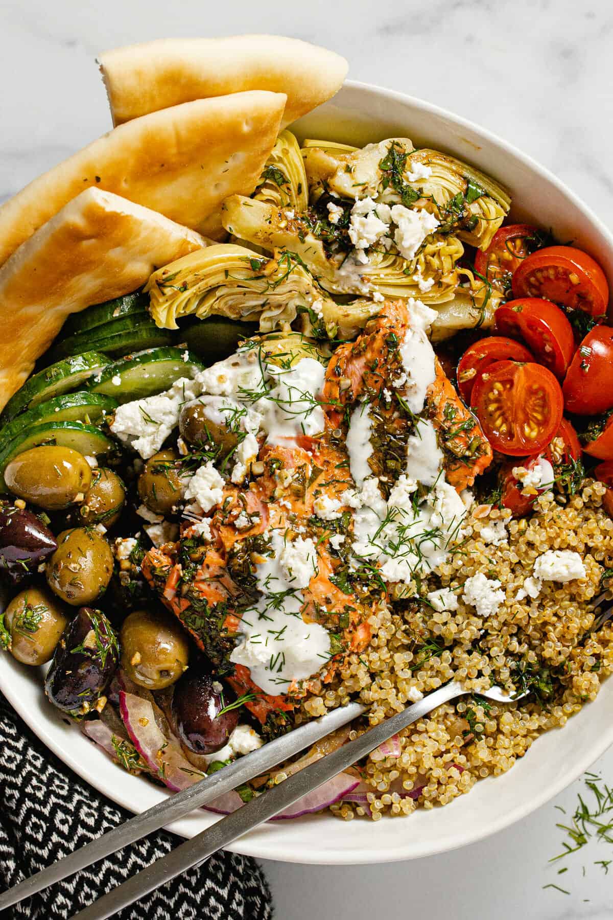 Large white bowl filled with Mediterranean salmon veggies and quinoa
