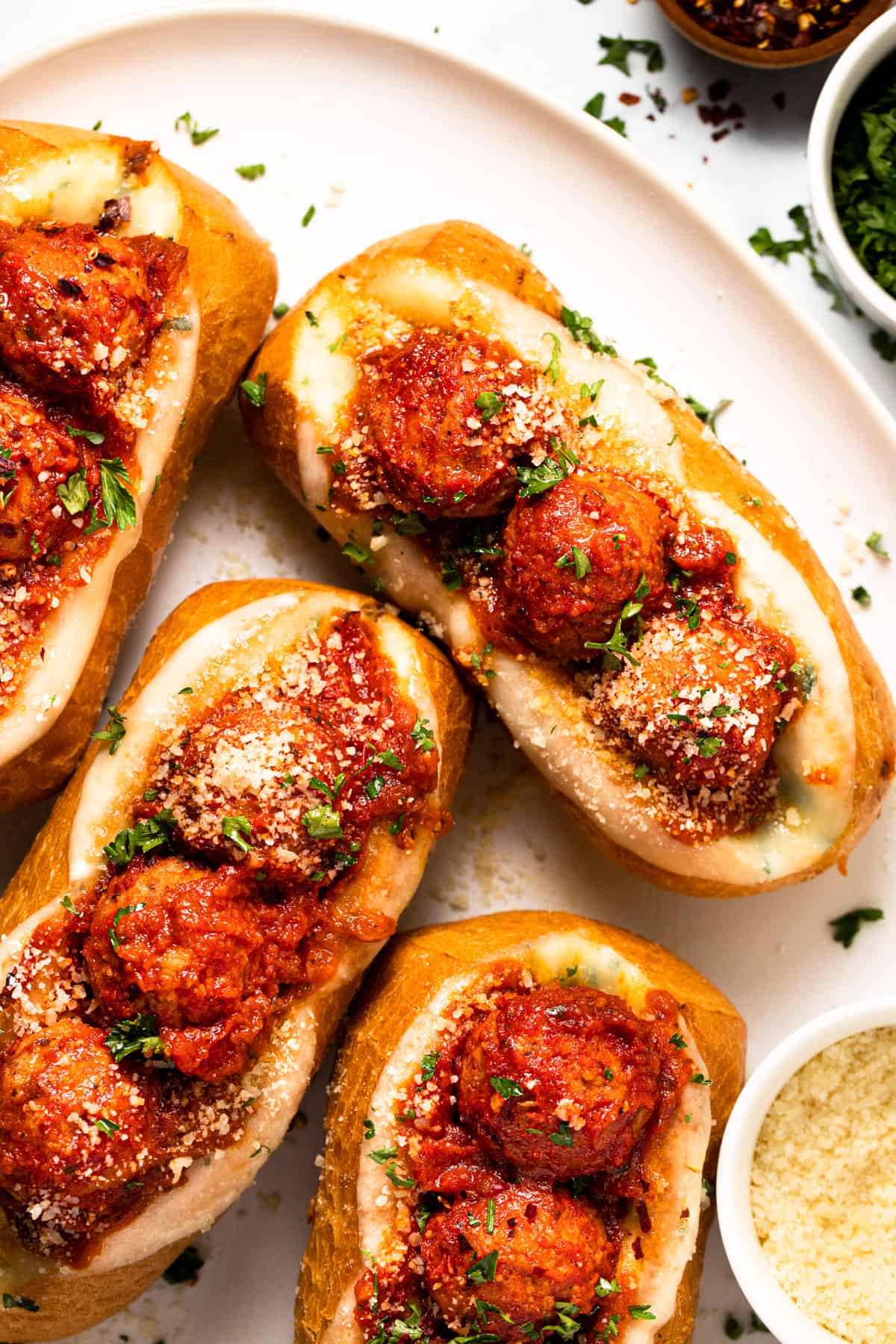 Meatball sub sandwiches on a large white platter.