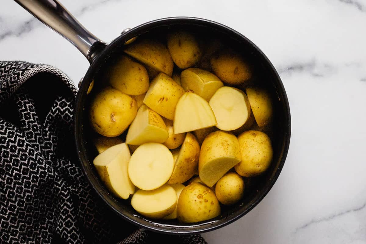 Small sauce pan with baby yellow potatoes and water