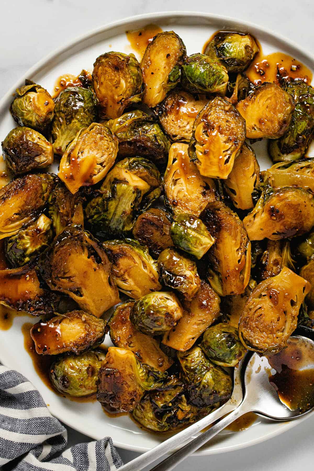 Overhead shot of balsamic glazed Brussel sprouts on a white plate