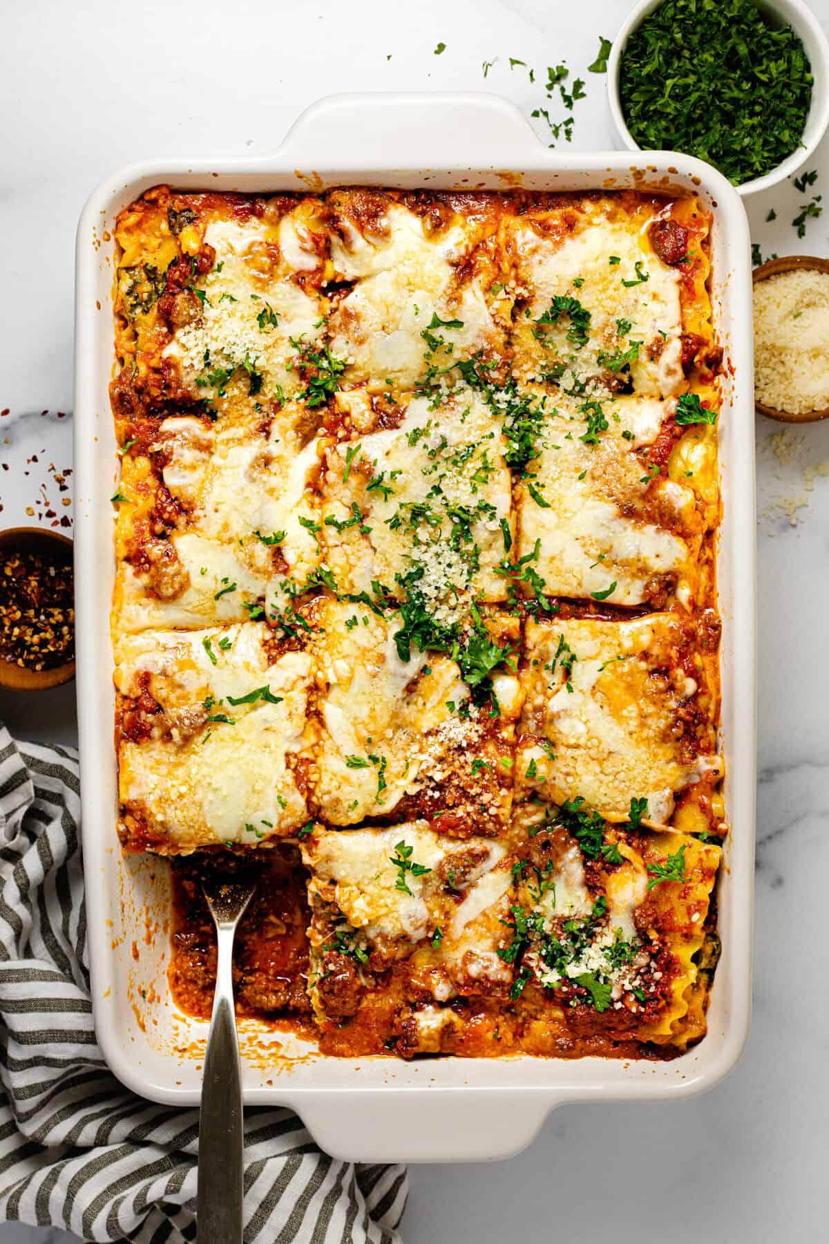 Large white baking dish filled with homemade cottage cheese lasagna garnished with parsley