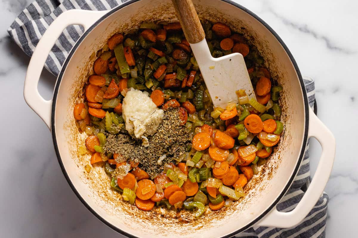 Large white pot filled with sautéed veggies garlic and herbs