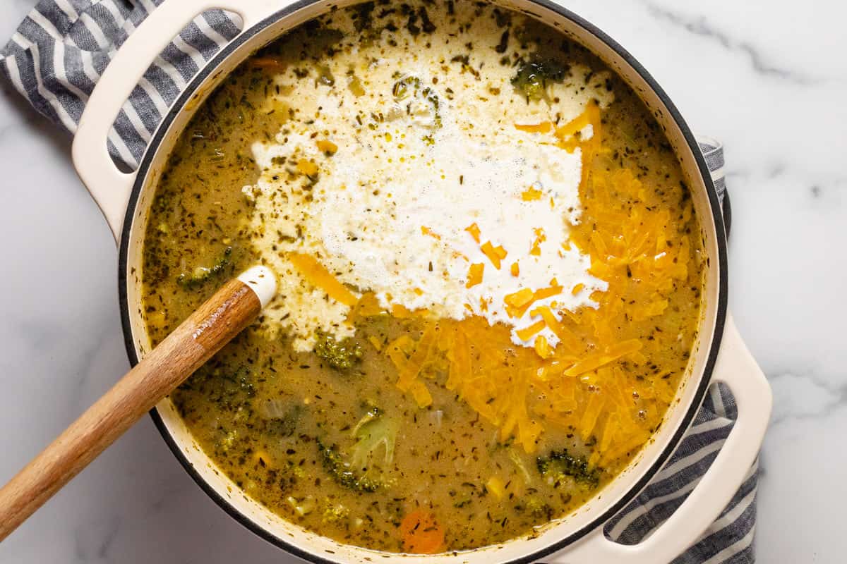 Large white pot filled with ingredients to make creamy vegetable soup