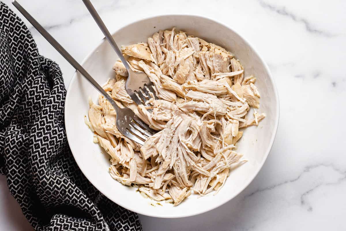 White bowl filled with shredded chicken breast