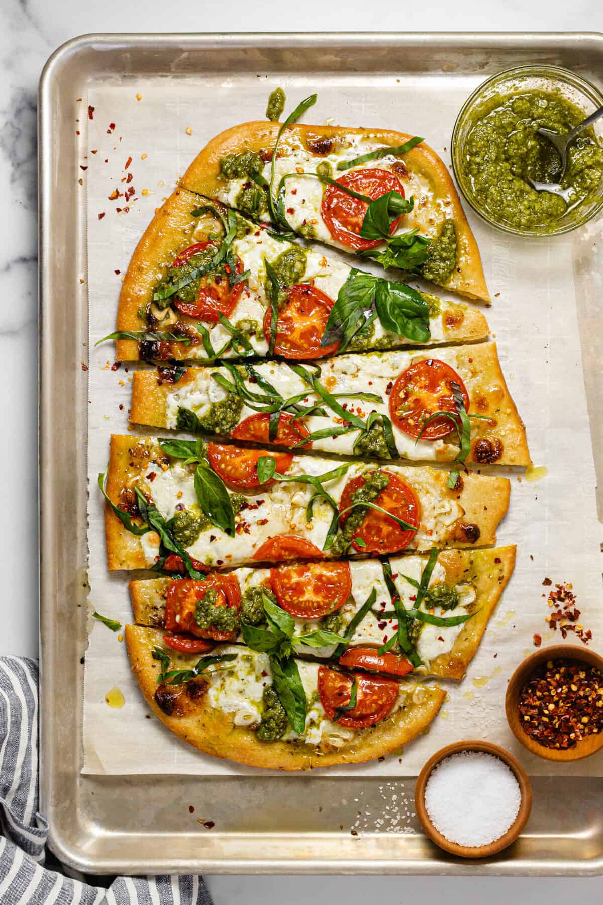 Homemade Margherita flatbread pizza on a parchment lined baking sheet