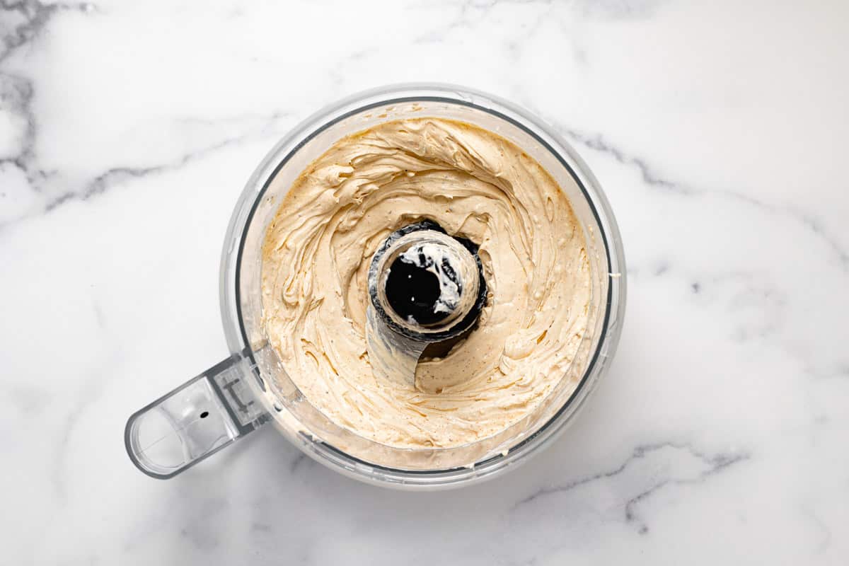 Food processor filled with ingredients to make creamy crab dip