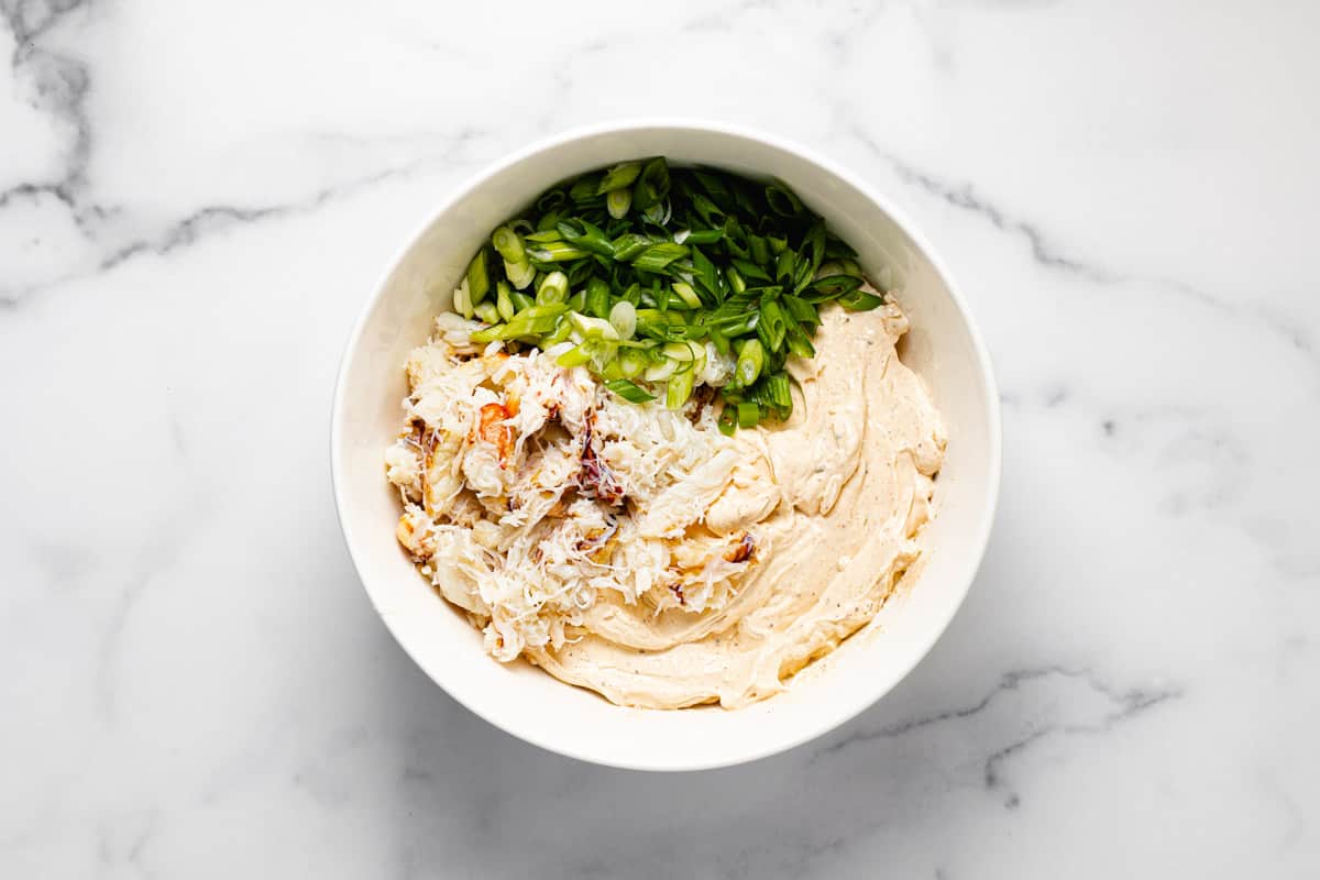 White bowl filled with ingredients to make creamy baked crab dip
