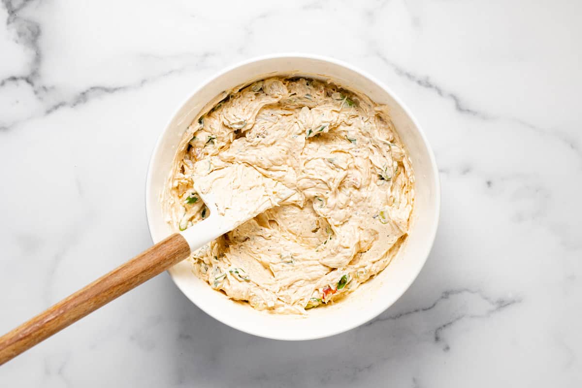 White bowl filled with ingredients to make creamy baked crab dip