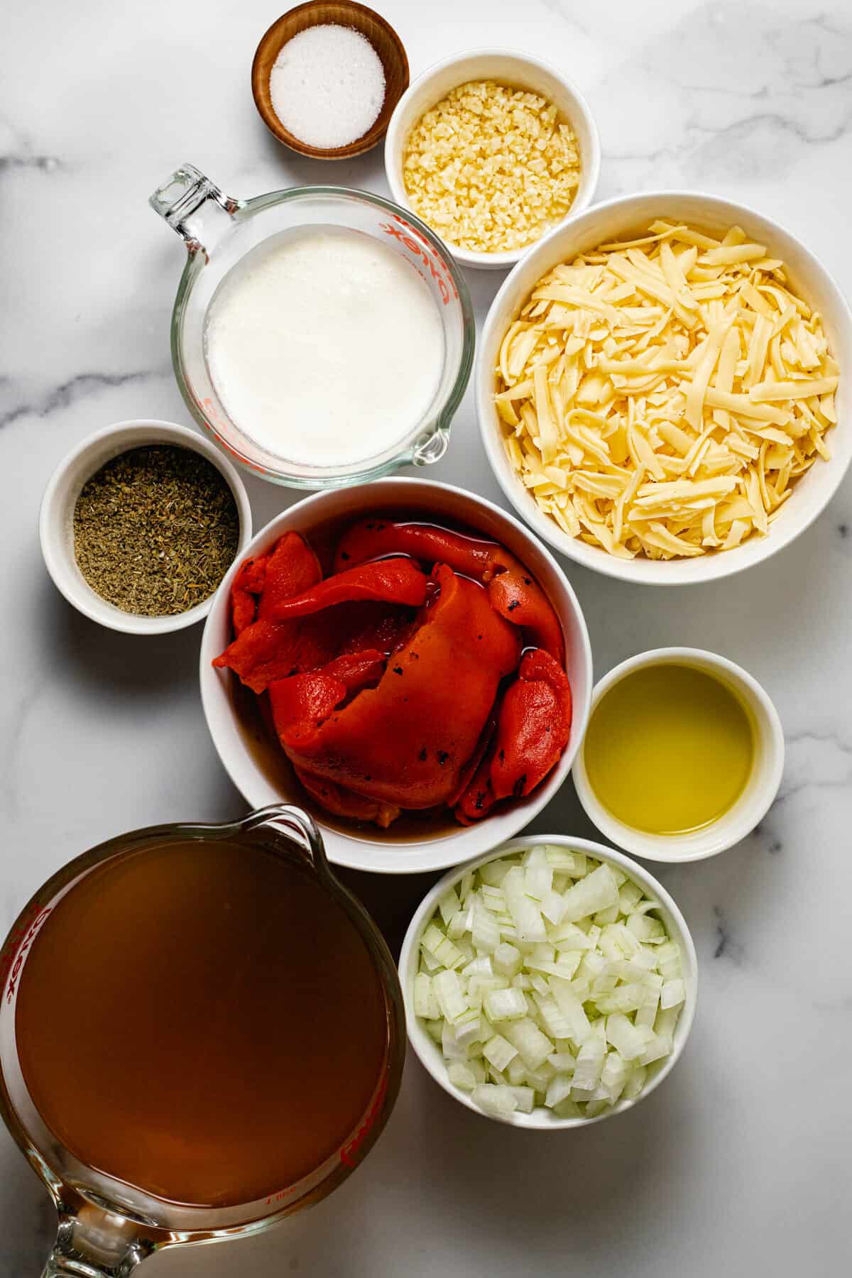 White marble counter top with ingredients to make homemade roasted red pepper soup