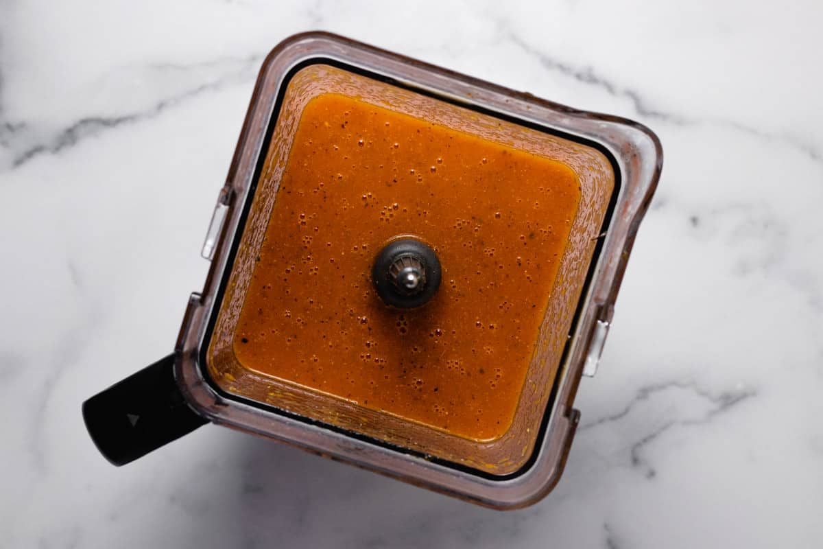 Overhead shot of a blender filled with roasted red pepper soup