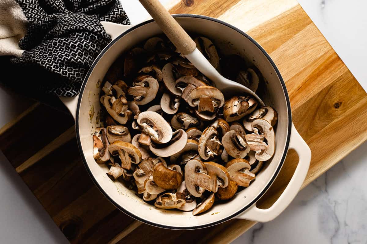 White pot filled with ingredients to make creamy vegan mushroom soup