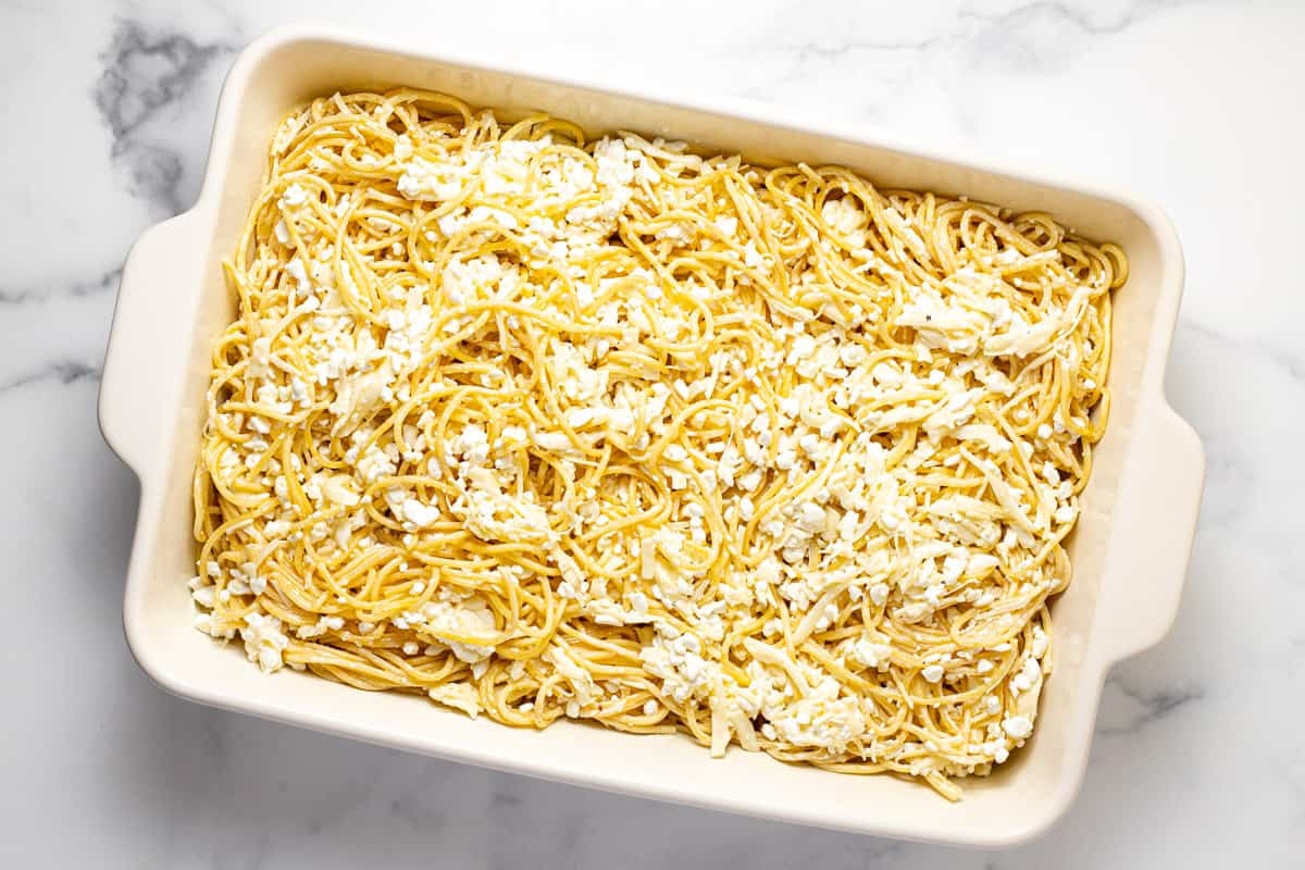 White baking dish filled with creamy spaghetti noodles coated in cheese