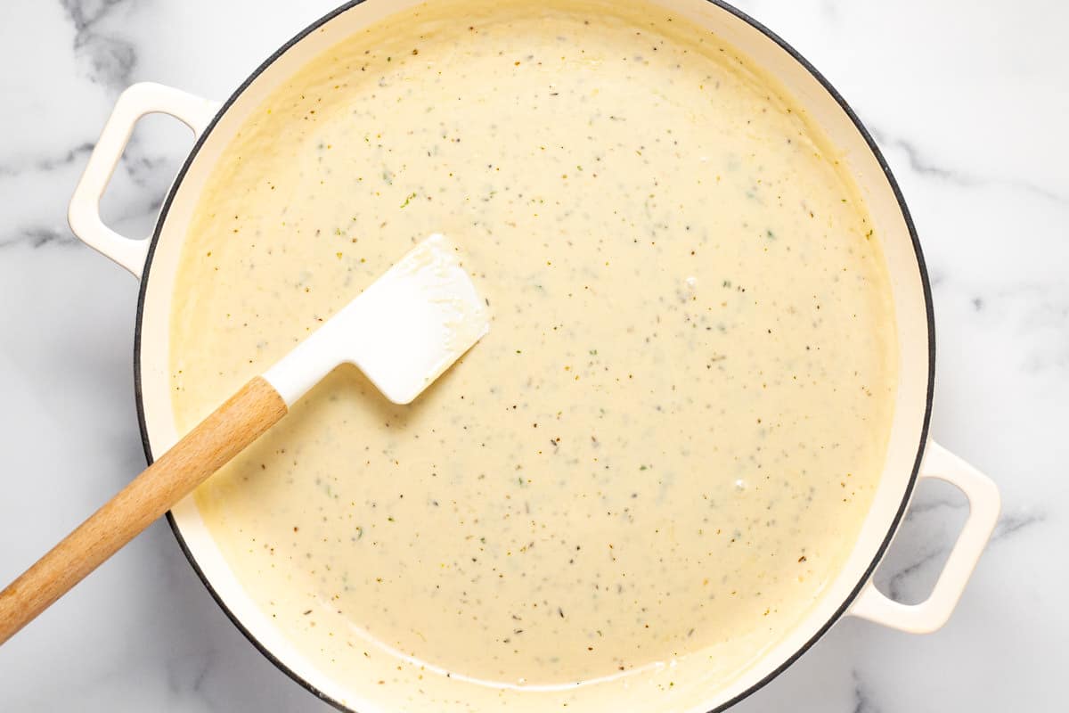 Large white sauté pan filled with creamy Parmesan garlic sauce