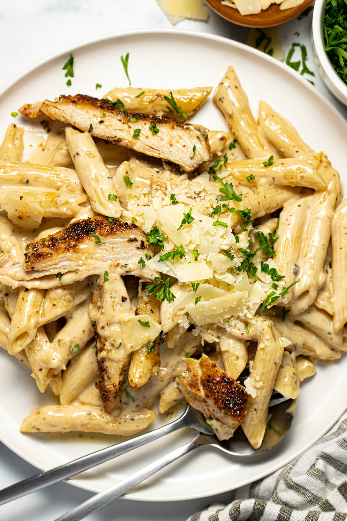 Large white plate filled with creamy penne chicken alfredo pasta
