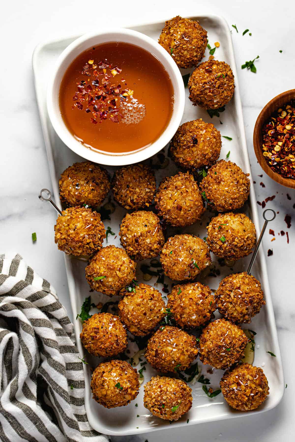 White rectangle platter with fried goat cheese balls on it