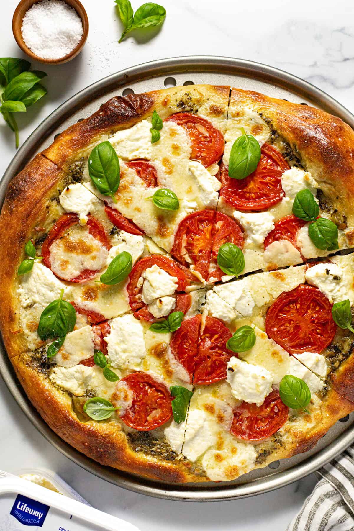 Three cheese Caprese pizza topped with basil